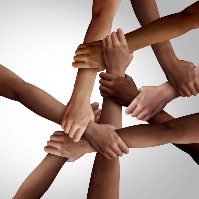 Business diversity and teamwork as a group of diverse people holding arms as a multiracial society and corporate multicultural community joined and united team building as a together and togetherness concept.